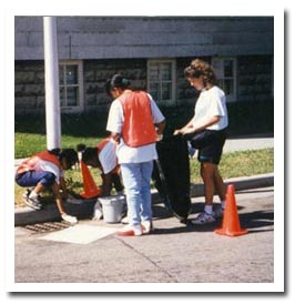 A group of volunteers stenciling a storm water inlet